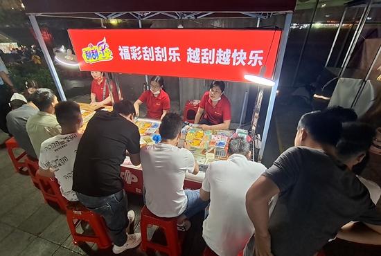 彩票销售员给青年购彩者讲解游戏玩法