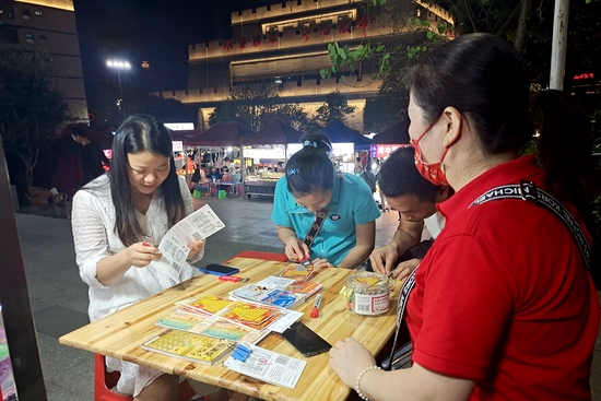 三两知己围坐在一起，刮着彩票，时不时传来欢笑声。