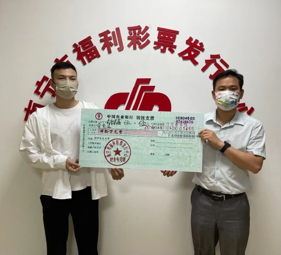 图1:南宁市福彩中心工作人员为黄先生(左)颁奖