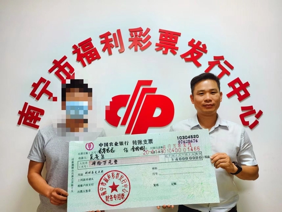 南宁市福彩中心工作人员为吴先生(左)颁奖
