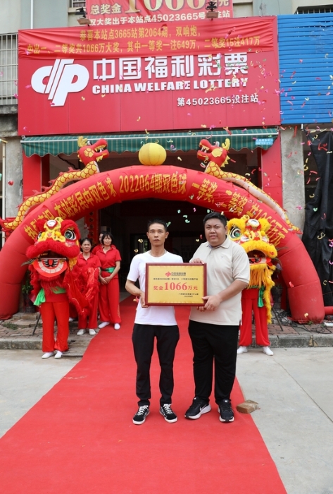 广西福彩中心桂中管理处工作人员（右一）向江先生颁发“大奖落户站”牌匾