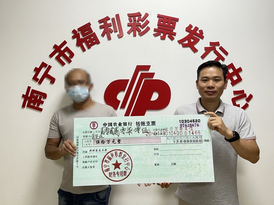 南宁市福彩中心工作人员为黄先生（左）颁奖