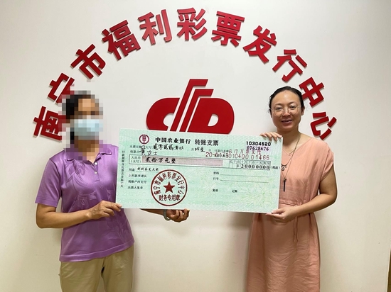 福彩中心工作人员为黄女士(左)颁奖