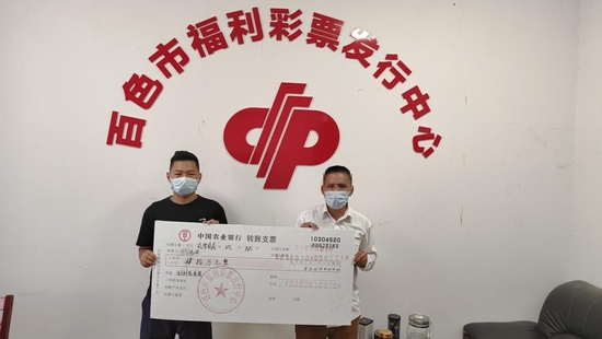 工作人员为中奖人黄先生(右)颁奖