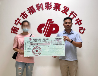 南宁市福彩中心工作人员为陆女士(左)颁奖