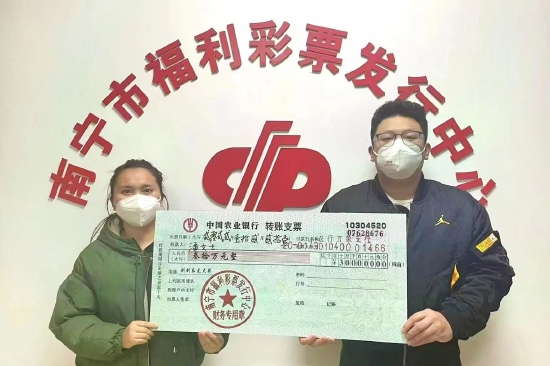 南宁市福彩中心工作人员为潘女士（左）颁奖