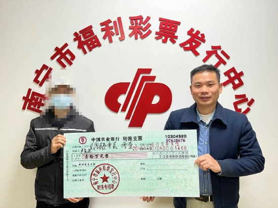 南宁市福彩中心工作人员为卢先生(左)颁奖