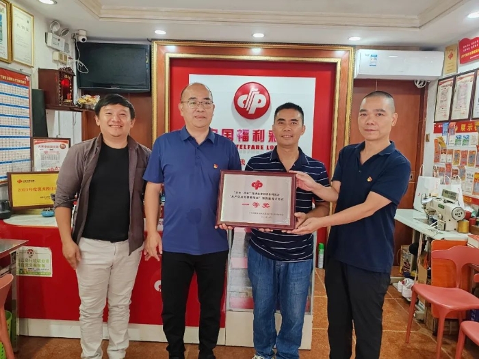 泉州福彩工作人员为黄金表（右二）颁发“共产党员先锋模范站”一等奖奖牌