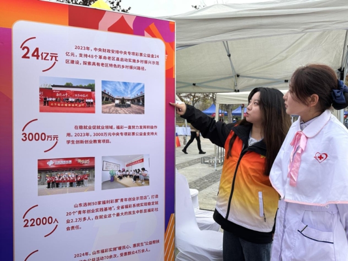 工作人员现场为市民介绍福彩公益金的组成及用途 工作人员现场为市民介绍福彩公益金的组成及用途