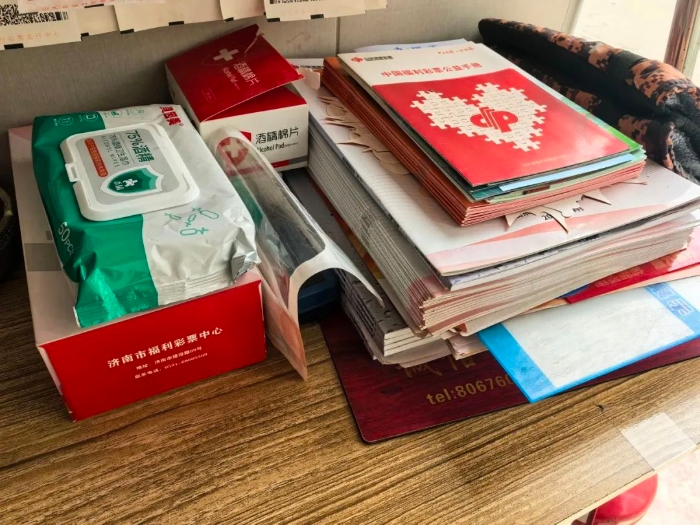 桌脚整王人摆放着《中国福利彩票公益手册》和乙醇消毒湿巾供彩友翻阅和使用。